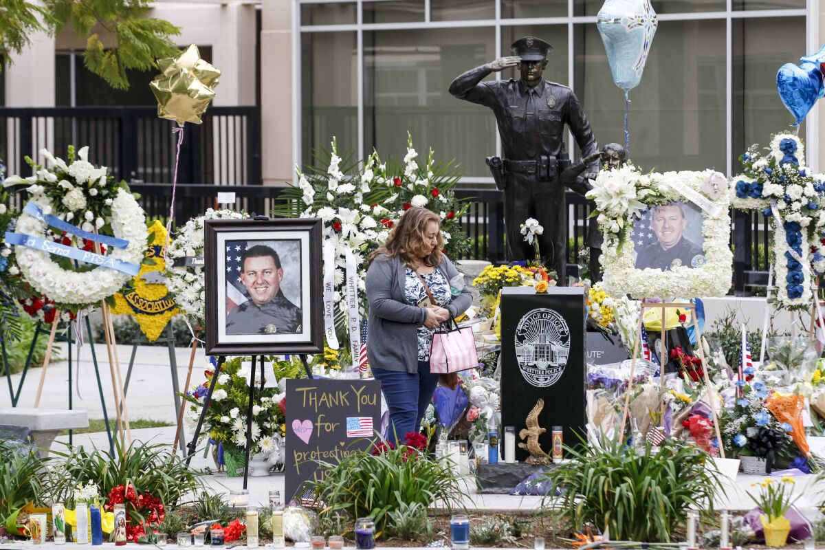A woman visits a makeshift memorial for slain Whittier police Officer Keith Boyer to pay her respects.