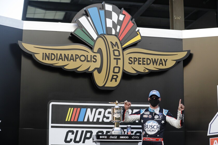 Race driver Kevin Harvick celebrates after winning the NASCAR Cup Series auto race at Indianapolis Motor Speedway.