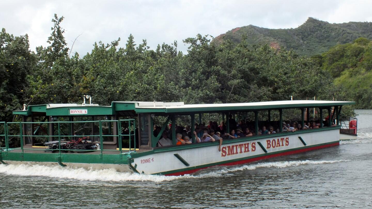 A boat loaded with visitors navigates the Wailea River on the island of Kauai. The Smith's tour company takes guests to a lush, hidden fern grotto during 1.5-hour journeys.