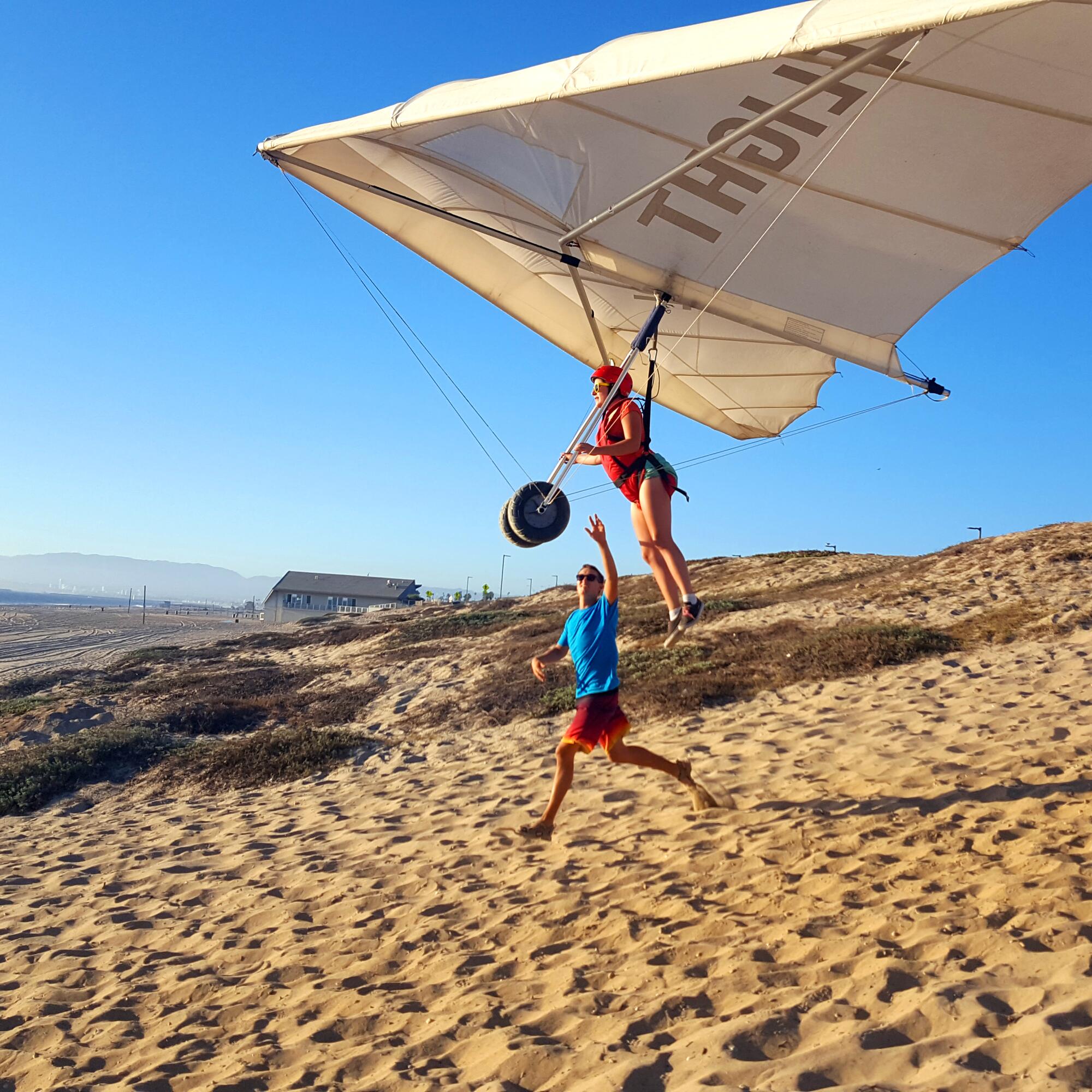 A woman takes flight on a hang glider.