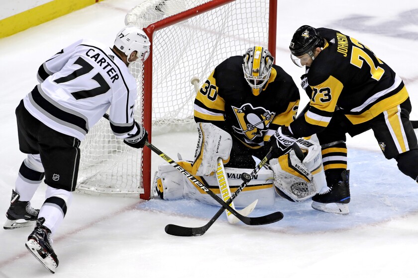 FILE - Los Angeles Kings' Jeff Carter (77) can't get his stick on a rebound in front of Pittsburgh Penguins goaltender Matt Murray (30) with Jack Johnson (73) defending during the first period of an NHL hockey game in Pittsburgh, in this Saturday, Dec. 15, 2018, file photo. All divisional play during this shortened NHL season gives an added perk to most of the players traded at the deadline: They'll get to face different teams. Jeff Carter is plenty used to Eastern opponents after starting with the Flyers but will be glad to play in front of some home fans with the Penguins. (AP Photo/Gene J. Puskar, File)