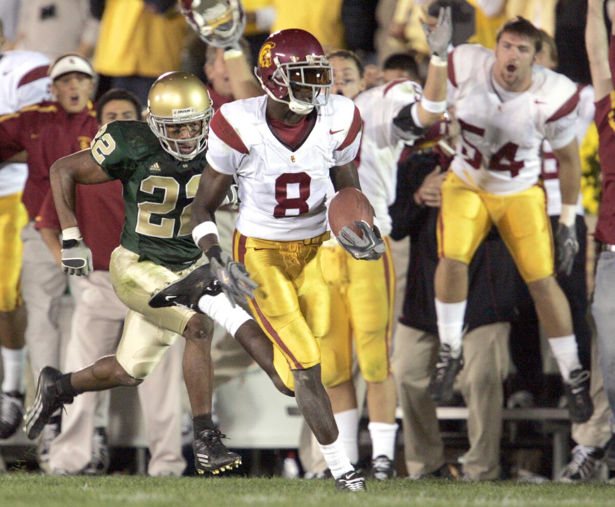 Gallardo, Alex –– – University of Southern California Trojan wide receiver Dwayne Jarrett runs away after catching a pass over Notre Dame Irish Ambrose Wooden (on fourth down and 8 yards to go late in the fouirth quarter) to run 61–yards to the 13 to set up the game winning touchdown for Saturday Oct. 15, 2005 at College Stadium in South Bend, Indiana.