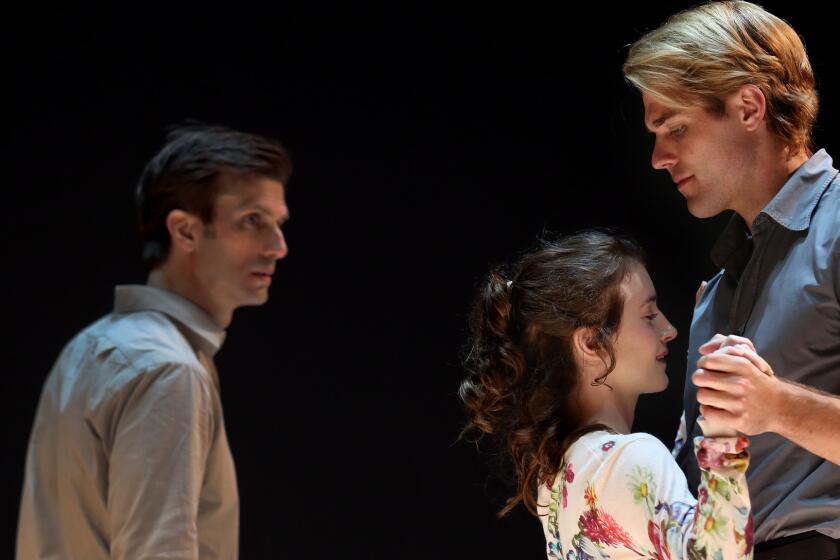 Eddie (Frederick Weller) looks on as Catherine (Catherine Combs) is held by Rodolpho (Dave Register) in director Ivo van Hove's production of Arthur Miller's "A View From the Bridge" at the Ahmanson Theatre.