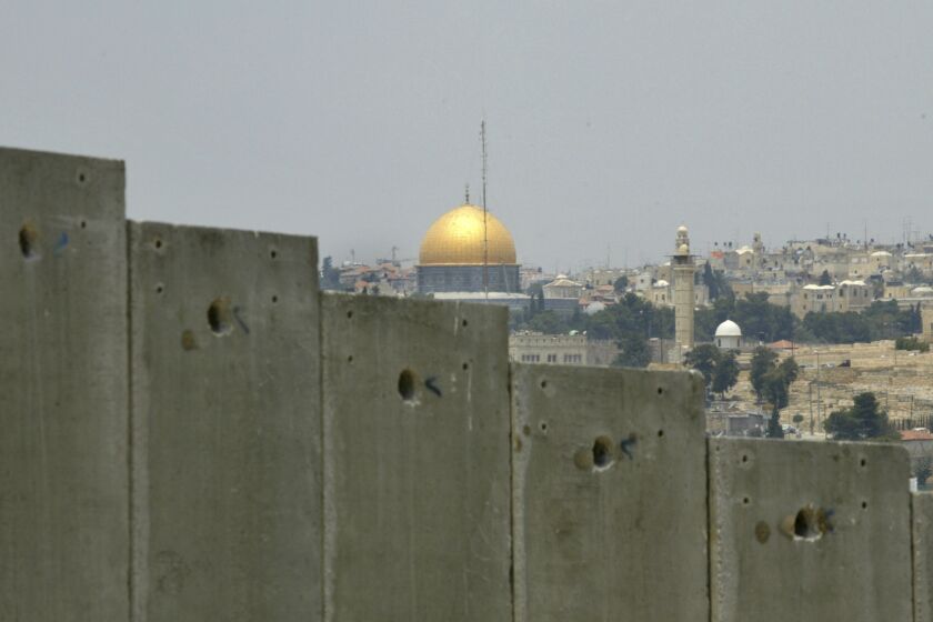 FILE - This July 9, 2004 file photo shows the golden shrine of the Dome of the Rock in Jerusalem's Old city can be seen behind a section made of concrete walls of the controversial separation barrier Israel is building in the village of Abu Dis in the outskirts of Jerusalem. In the 1948 war surrounding Israel's creation, Egyptian forces took control of the Gaza Strip and Jordan took over the West Bank and east Jerusalem. Israel captured the territories when it launched a surprise attack in 1967 at a time of soaring tensions with its hostile Arab neighbors. (AP Photo/Enric Marti, File)