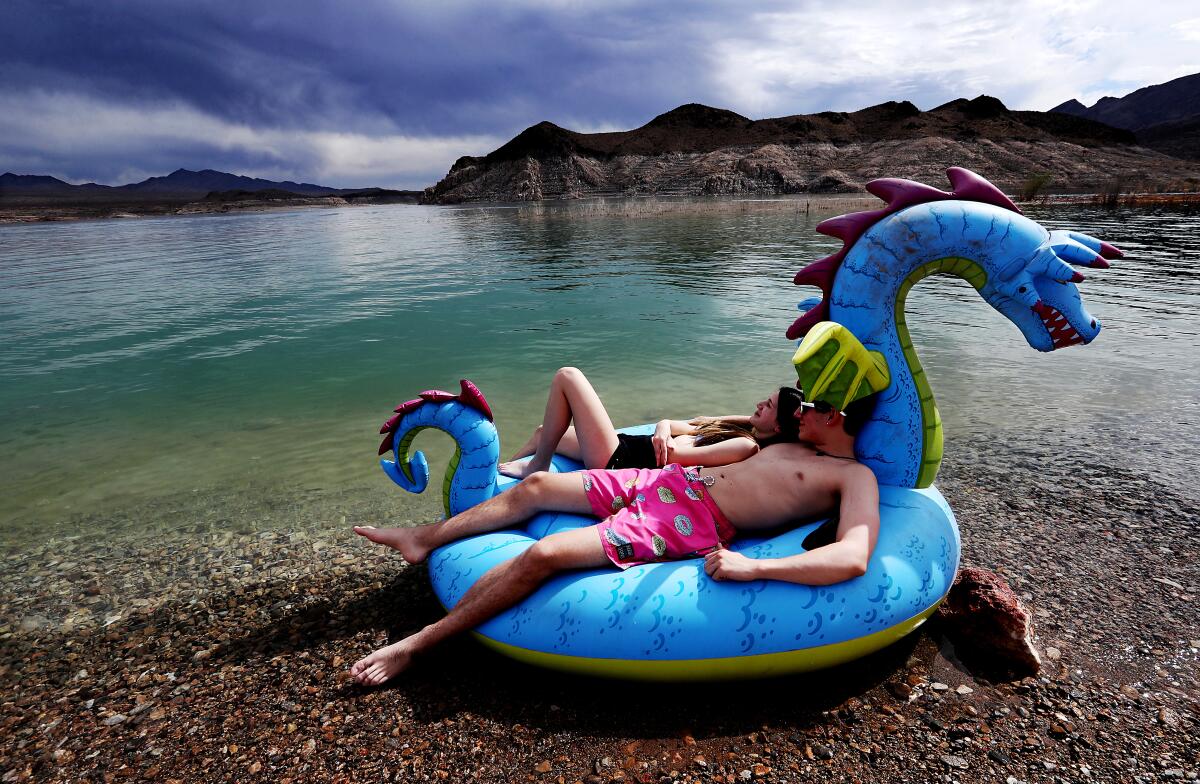 Storm clouds float across the sky but leave little rain as teens enjoy the shore of Lake Mead.