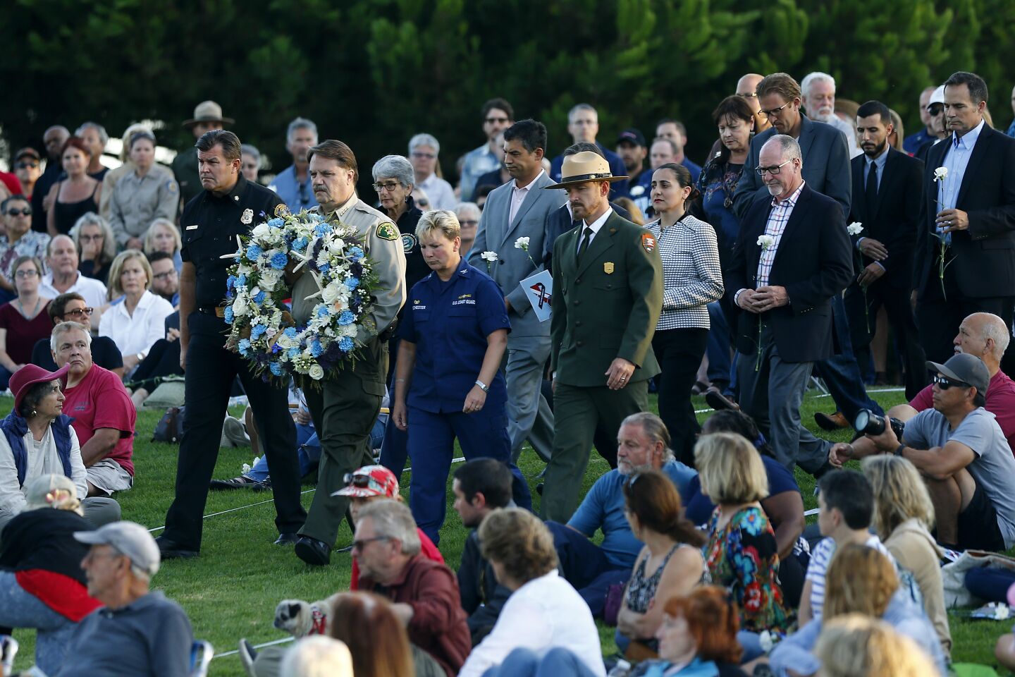 Santa Barbara County Sheriff Bill Brown, with other officials, presents a wreath during the vigil at Chase Palm Park in Santa Barbara on Friday evening homor the 34 victims of the Conception boat fire.