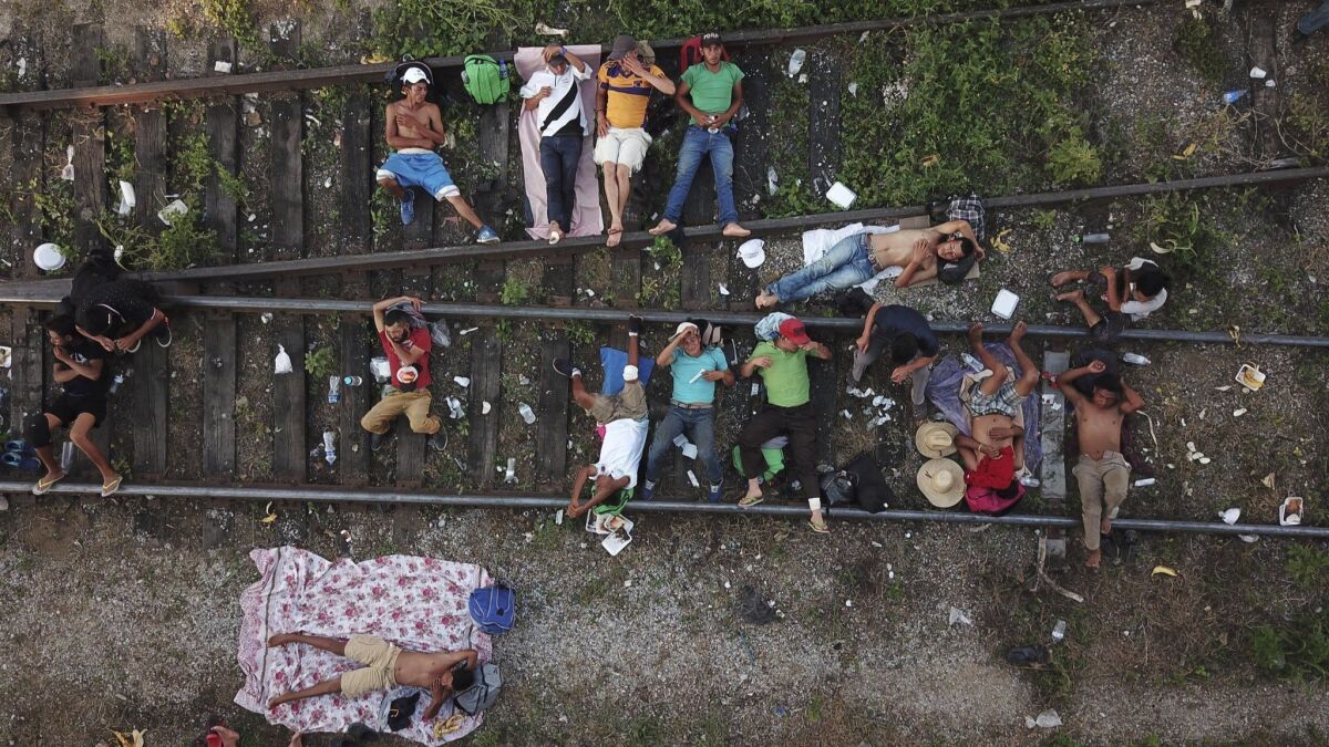 Central American migrants who are part of a caravan slowly making its way toward the U.S.-Mexico border rest on railroad tracks in Arriaga, Mexico, on Oct. 26, 2018.