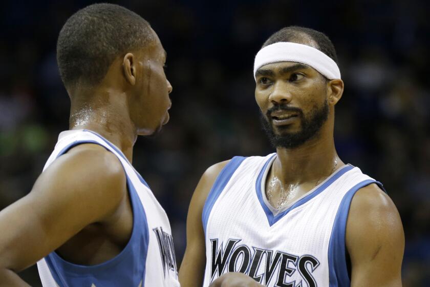Minnesota Timberwolves teammates Andrew Wiggins, left, and Corey Brewer talk during a game against the Sacramento Kings on Saturday.