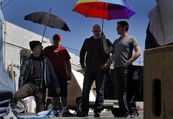 Film crew shades actors David Meunier, left, and Corey Stoll, center, during filming in San Pedro for "Law & Order: Los Angeles," the new entry in the "Law & Order" franchise. Like the original show, the drama will be half police investigation, half legal drama.