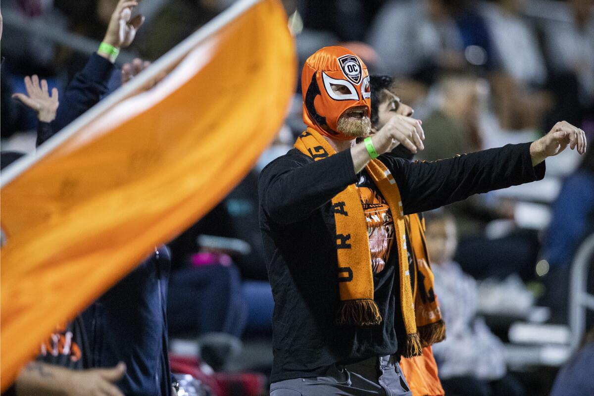 An Orange County Soccer Club fan wears a mask during a game against the San Diego Loyal at Championship Soccer Stadium.