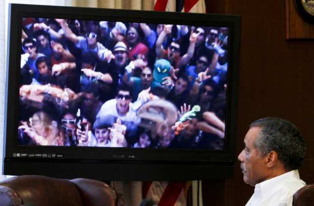 Los Angeles city councilman Bernard Parks at a meeting of the Coliseum Commission in February 2011, looking at a photo of the Electric Daisy Carnival rave the previous summer.