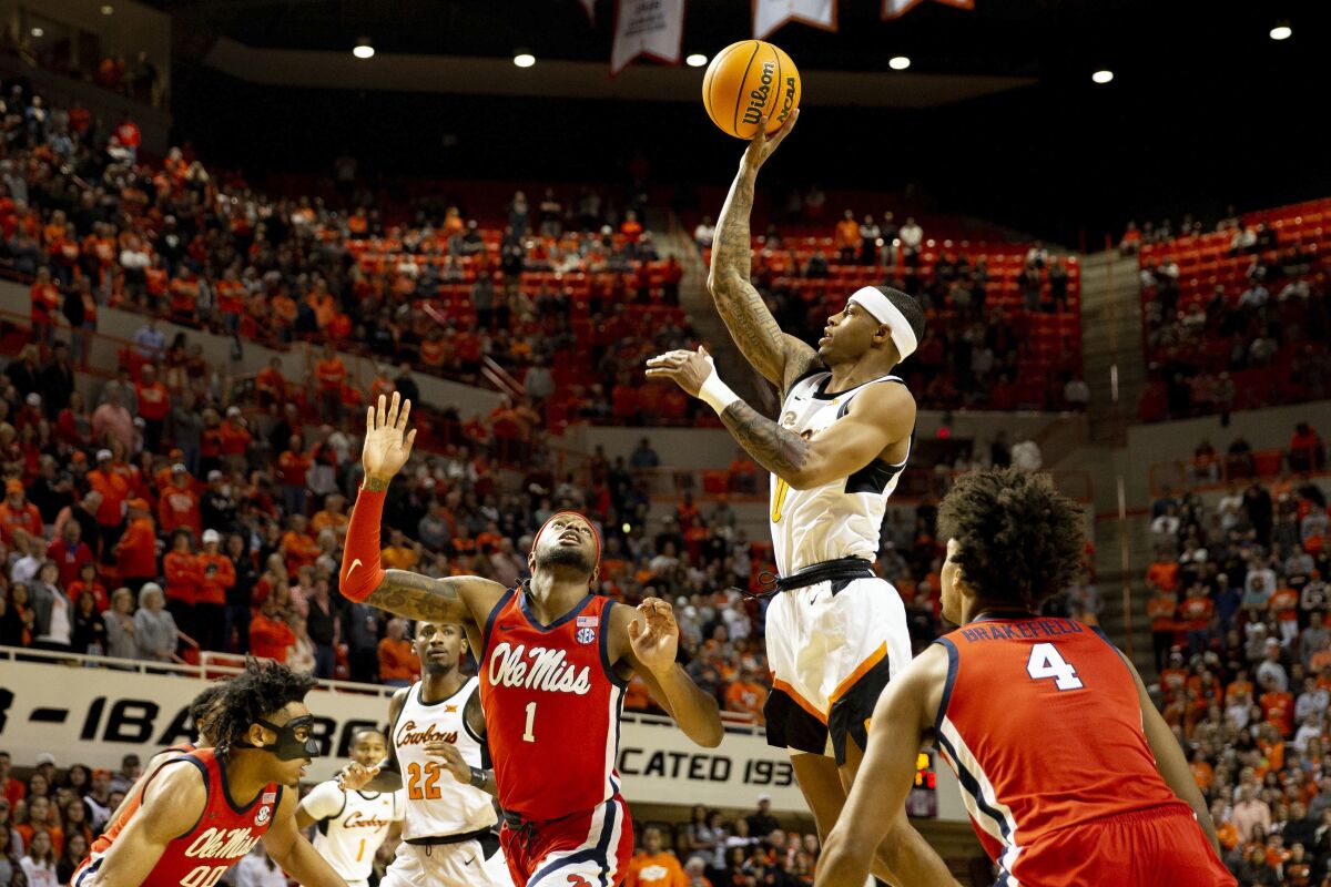 Oklahoma State's Avery Anderson III, second from right, shoots over Mississippi's Amaree Abram (1) during the first half of an NCAA college basketball game in Stillwater, Okla., Saturday, Jan. 28, 2023. (AP Photo/Mitch Alcala)