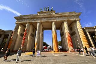 Members of the climate protection group Last Generation have sprayed the Brandenburg Gate with orange paint in Berlin, Germany, Sunday, Sept. 17, 2023. All six columns were affected, said a police spokesman on Sunday morning. Emergency forces were on the scene, there had been arrests. The Last Generation said that prepared fire extinguishers had been used for the action. (Paul Zinken/dpa via AP)