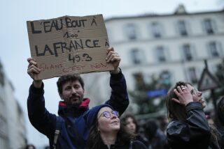 Un manifestante alza un cartel que dice "el agua hierve a los 100 grados, Francia hierve a los 49,3. 64 años es no", durante una protesta en París, el miércoles 22 de marzo de 2023. Las huelgas complicaban los desplazamientos el jueves en Francia, en las primeras acciones sindicales desde que el presidente, Emmanuel Macron, avivara la indignación ciudadana al imponer una subida de la edad de la jubilación sin votación parlamentaria. (AP Foto/Lewis Joly)