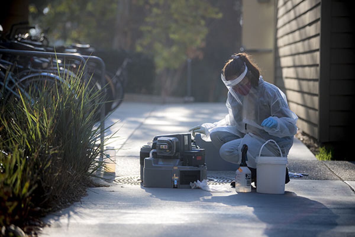 Smruthi Karthikeyan picks up wastewater samples from a collection point on the UC San Diego campus.