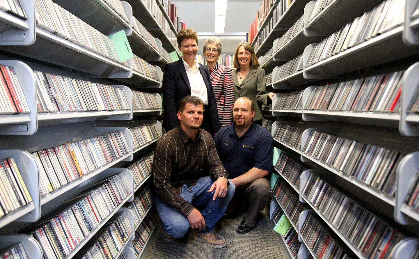 The remodeling team of Troy Parra, project manager with Spectra Company, Rueben Lombardo, project manager with Spectra Company, Debra Gerod, architect with Gruen Associates, Carolyn Flemming, library arts and culture building administrator, and Cindy Cleary, director of library arts and culture, stand in stacks loaded with CDs that are taller, an idea that allowed for several shelves of books to be relocated to different parts of the Brand Library without losing any shelf space in Glendale on Tuesday, March 25, 2014. The library, which as gone through extensive renovation and repair, will reopen again on Thursday. (Tim Berger/Staff Photographer)