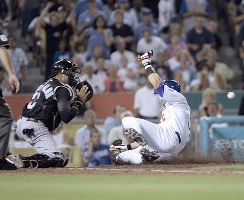 Dodgers Nomar Garciaparra slides ahead of the ball to score the Dodgers 13th run.