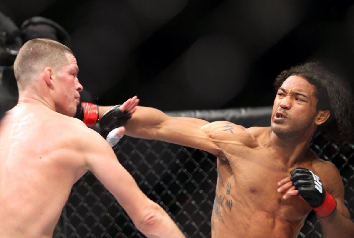 Nate Diaz, left, gets hit by Benson Henderson on Saturday.