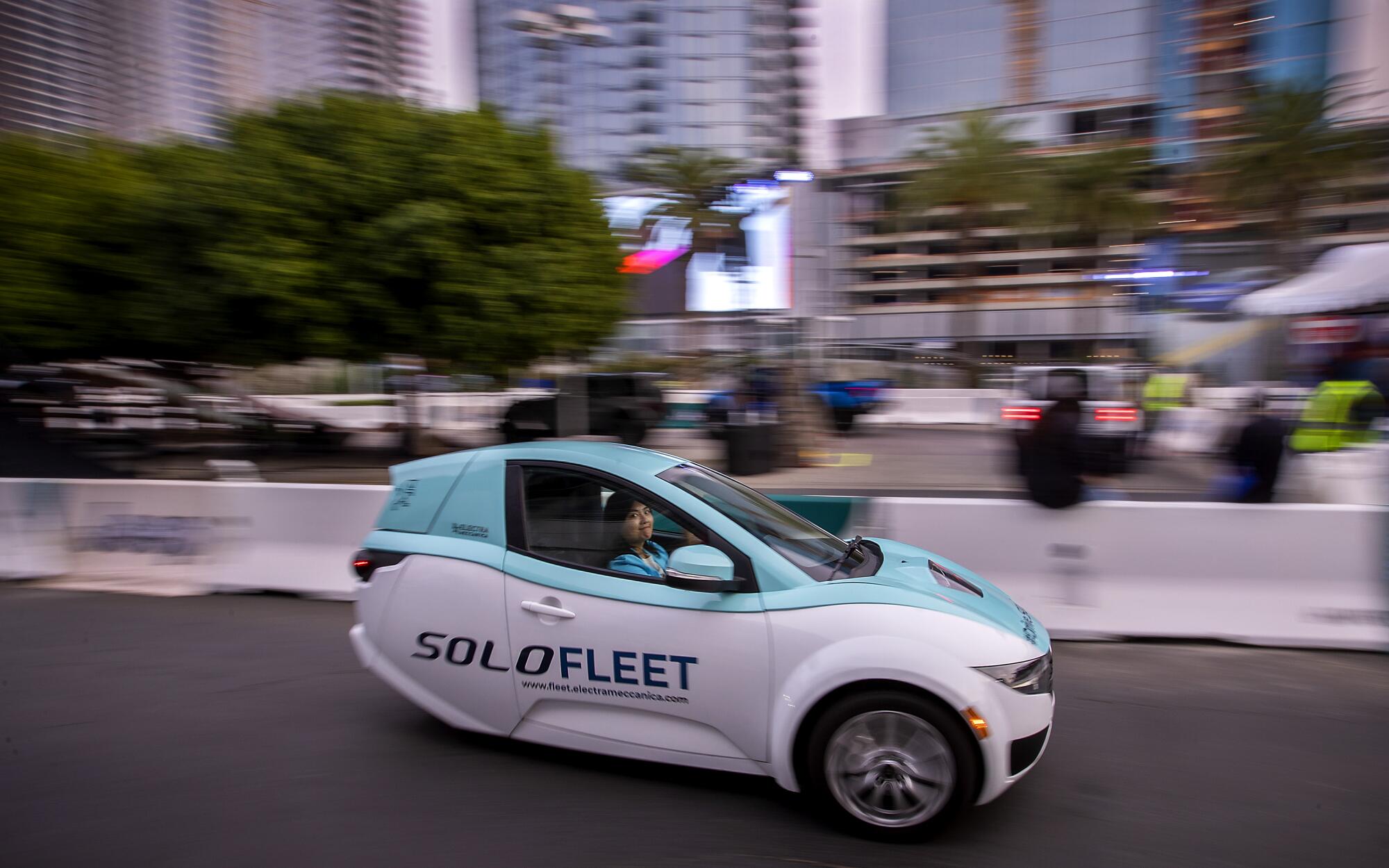 A visitor to the L.A. Auto Show test-drives a SOLO electric vehicle.