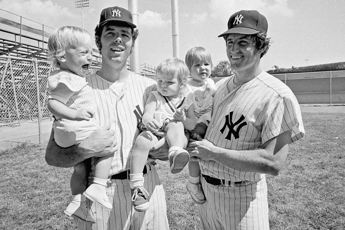 FILE - New York Yankees pitchers Mike Kekich, left, and Fritz Peterson have their arms full of kids after they showed up at the spring training camp at Fort Lauderdale, Fla., Feb. 28, 1972. Kekich holds crying son Jim and daughter Regan, and Peterson holds his son Eric. Peterson, the New York Yankees pitcher who created a controversy when he swapped wives and families with teammate Mike Kekich in 1973, died of lung cancer at his home in Winona, Minn., on Oct. 19, according to the death certificate filed with the Winona County Vital Records Department. He was 81. (AP Photo/Joe Migon, File)