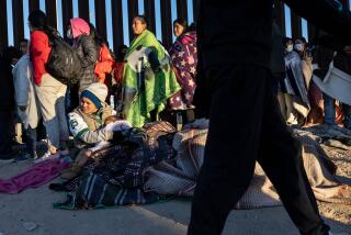 EL PASO, TEXAS - DECEMBER 22: Immigrants bundle up against the cold after spending the night camped alongside the U.S.-Mexico border fence on December 22, 2022 in El Paso, Texas. A spike in the number of migrants seeking asylum in the United States has challenged local, state and federal authorities. The numbers are expected to increase as the fate of the Title 42 authority to expel migrants remains in limbo pending a Supreme Court decision expected after Christmas. (Photo by John Moore/Getty Images)
