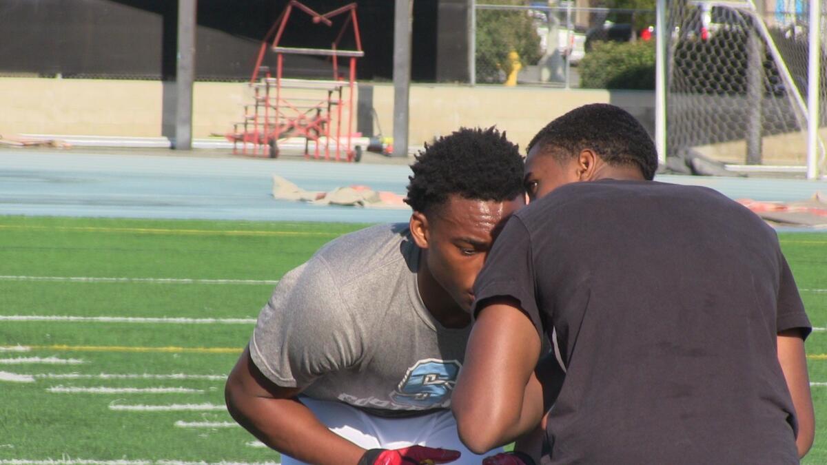 Salesian's Deommodore Lenoir is showing off his man-to-man coverage technique in a passing practice against Crenshaw.