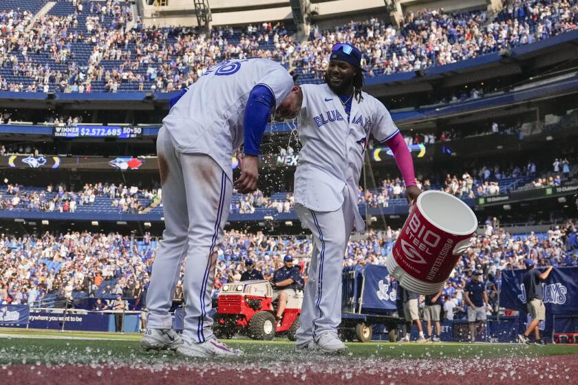 Toronto Blue Jays' Matt Chapman, left, is doused by teammate Vladimir Guerrero Jr., right, after hitting a walkoff double against the Boston Red Sox in baseball game action in Toronto, Sunday, Sept. 17, 2023. (Andrew Lahodynskyj/The Canadian Press via AP)
