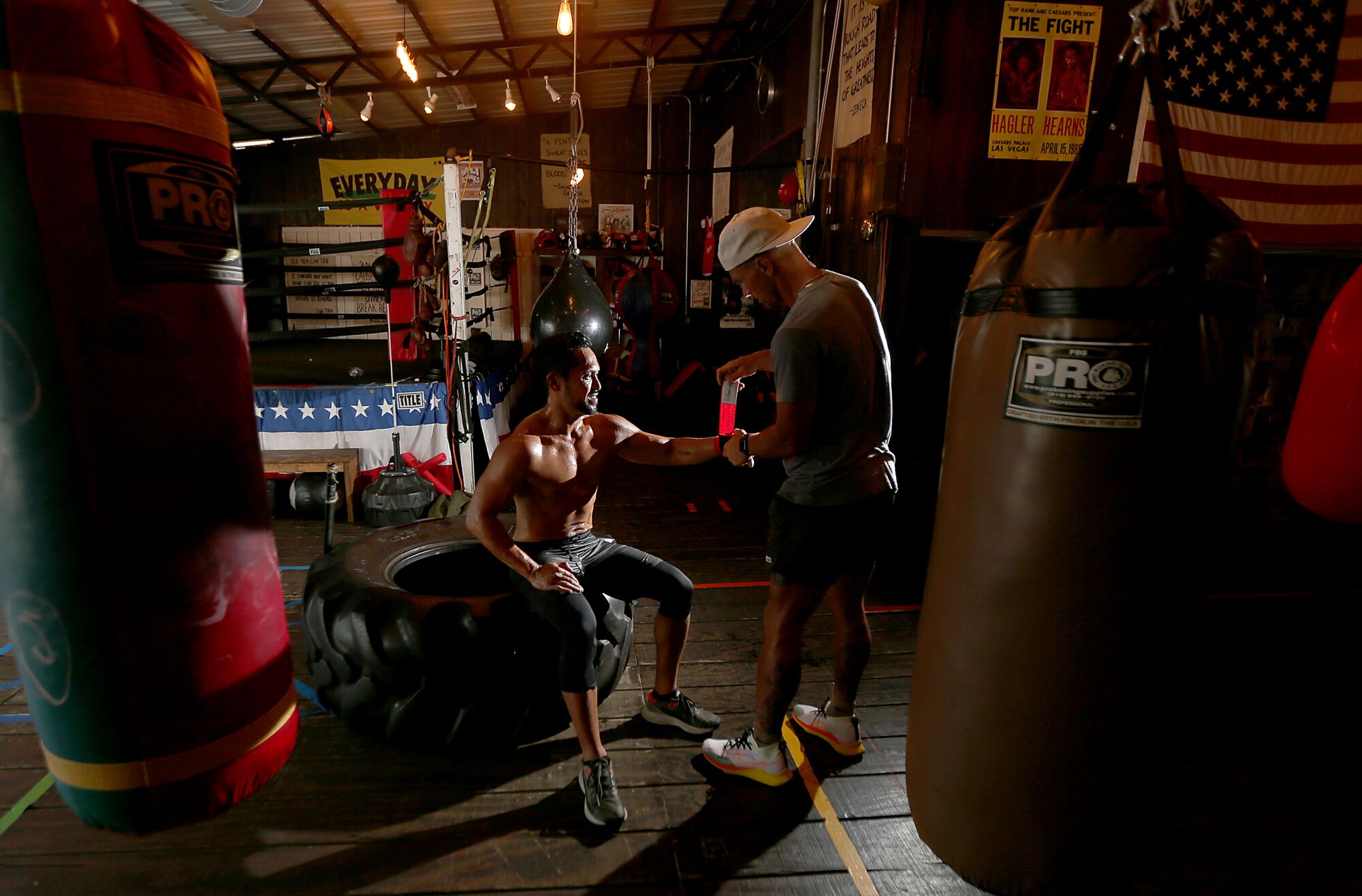 Boxing trainer Tyler Wood helps Joel Relampagos with an arm wrap