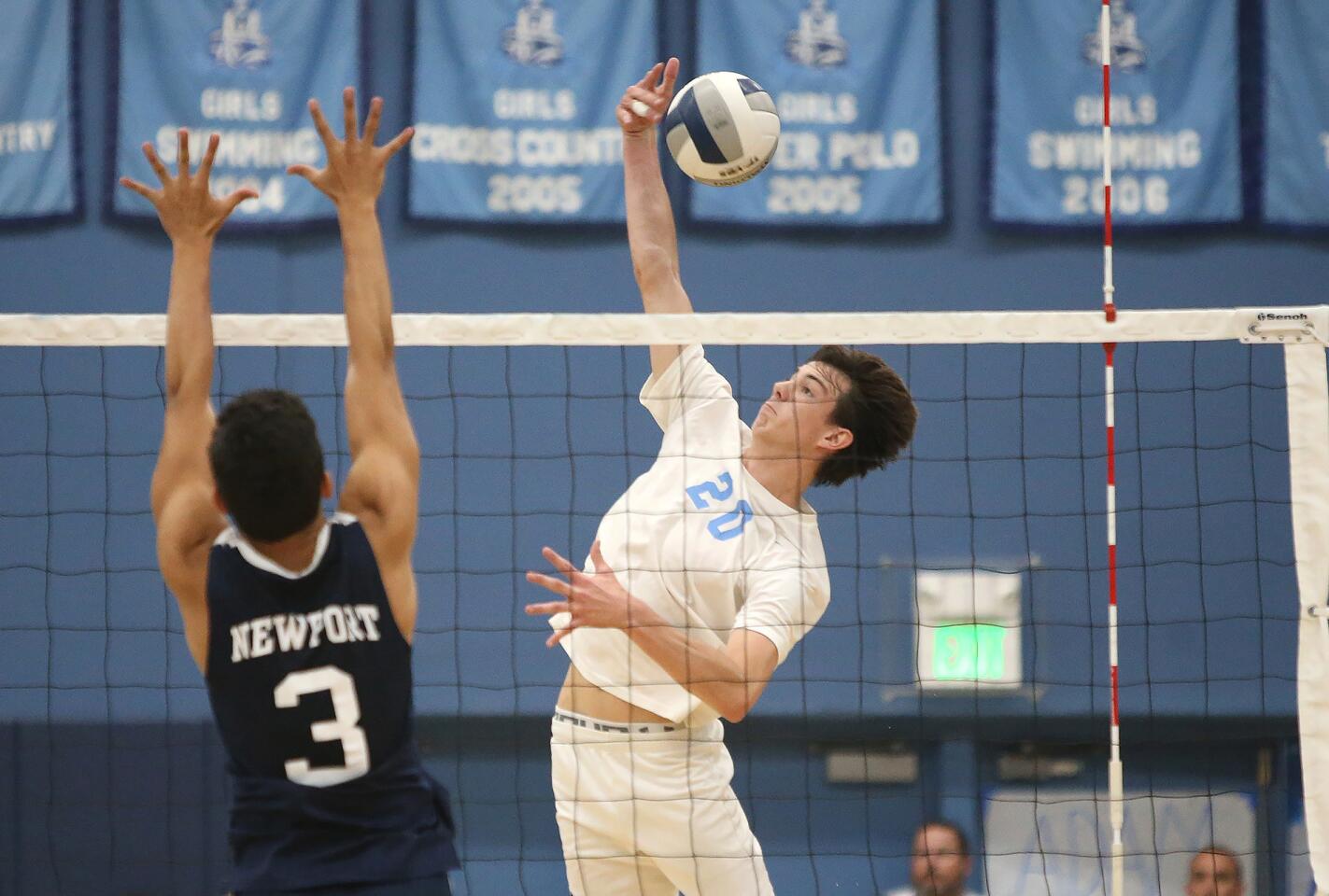 Corona del Mar's Adam Flood (20) makes a kill past Newport Harbor's Joe Karlous during second round of the Battle of the Bay boys' volleyball match in Surf League play on Wednesday.
