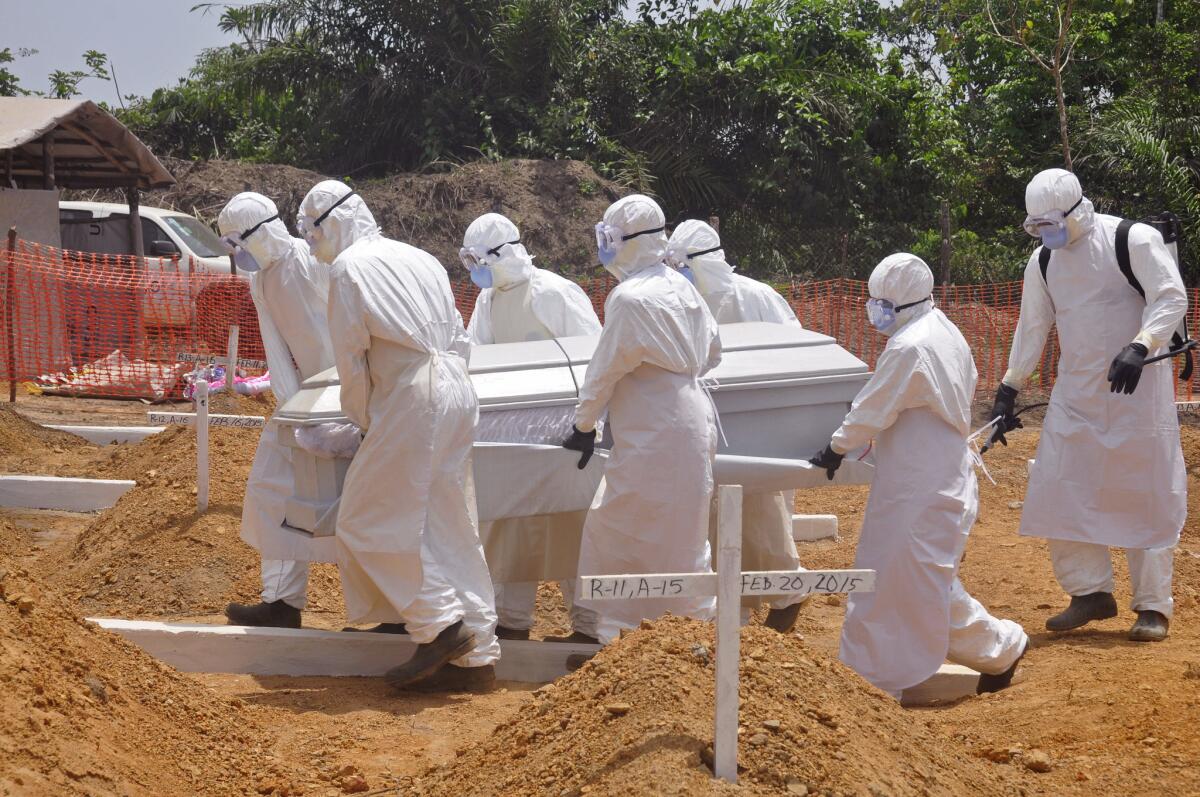 In this Wednesday, March 11, 2015, file photo, health workers carry the body of a person that they suspected died form the Ebola virus at a new graveyard on the outskirts of Monrovia, Liberia. After Liberia was twice declared free of the disease, a new case has been discovered.
