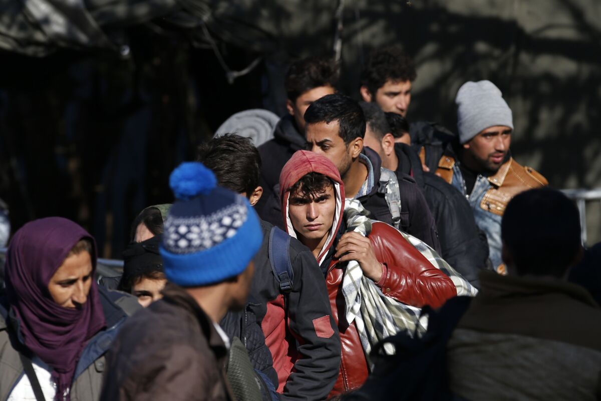 Syrian migrants wait to register with the police at the refugee center in the southern Serbian town of Presevo.