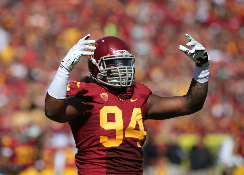 USC defensive end Leonard Williams gestures to the crowd during a home game against Utah State on Sept. 21.
