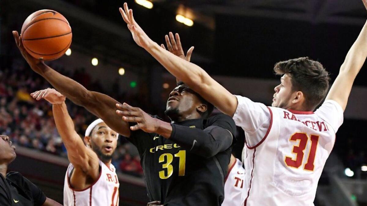 Oregon guard Dylan Ennis shoots as USC forward Nick Rakocevic, right, defends during the first half of a game on Feb. 11.