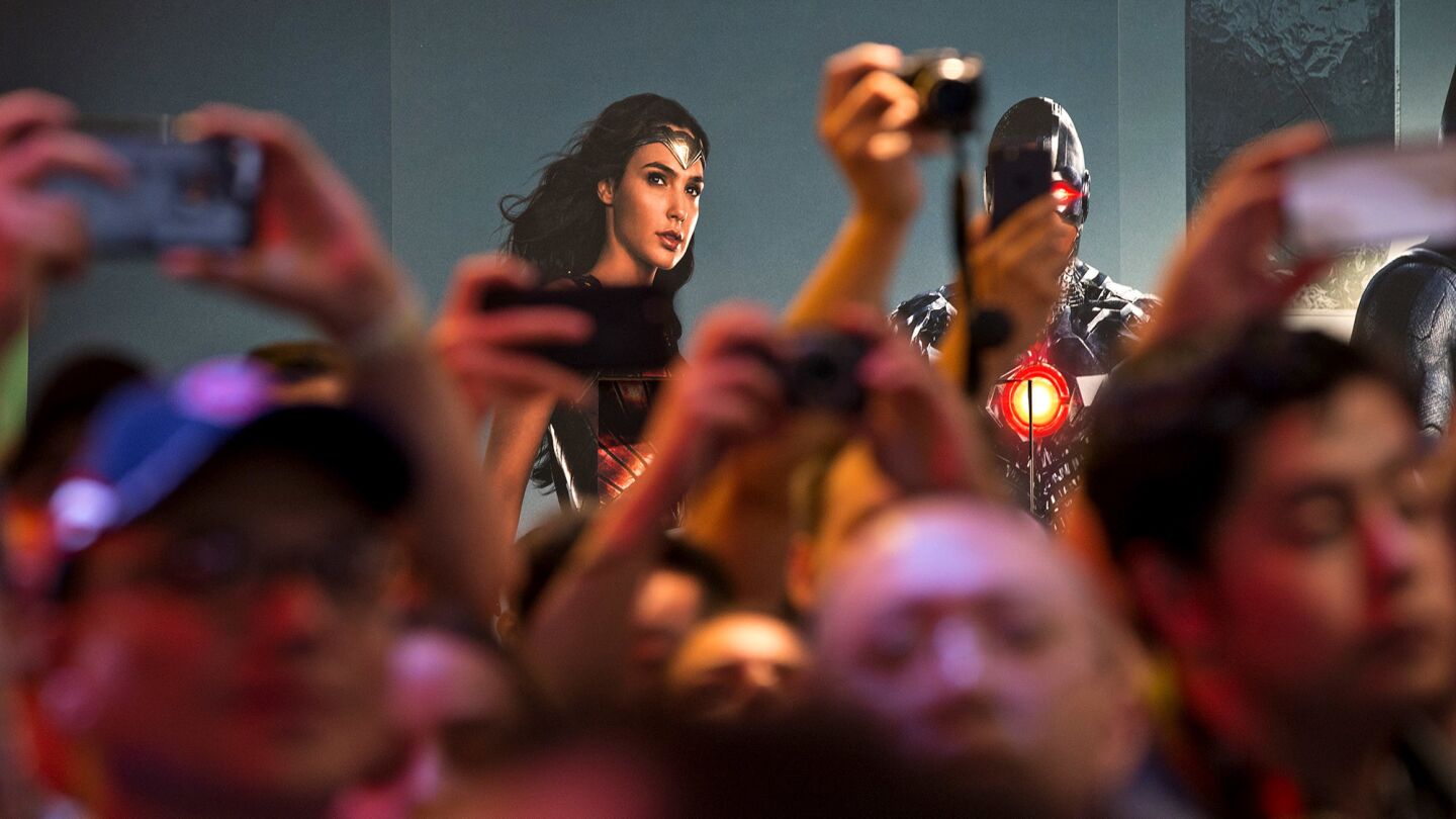 The image of Wonder Woman, portrayed by Gal Gadot, serves as a backdrop as fans gather Saturday at the DC Comics booth at Comic-Con.