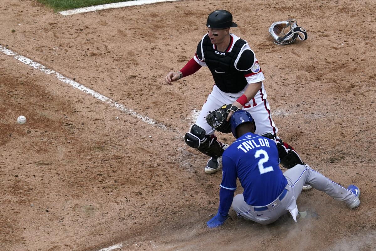 Kansas City Royals' Michael A. Taylor (2) scores on a throwing error by Chicago White Sox relief pitcher Garrett Crochet as catcher Zack Collins, top, watches the ball during the 10th inning of a baseball game in Chicago, Sunday, April 11, 2021. (AP Photo/Nam Y. Huh)