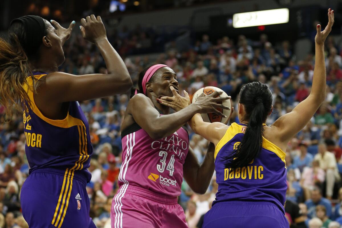 Lynx center Sylvia Fowles (34) protects the ball against the double-team defense of Sparks center Jantel Lavender, left, and guard Ana Dabovic in the second half Sunday.