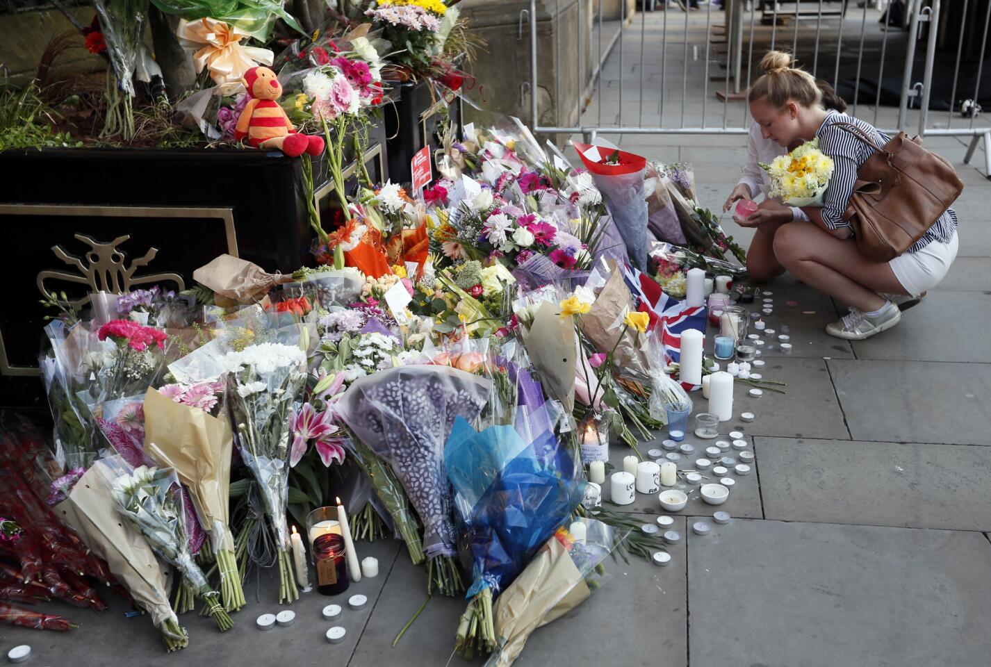 People lay flowers after a vigil in Manchester, England, on May 23, 2017, the day after a suicide attack at an Ariana Grande concert left 22 people dead.