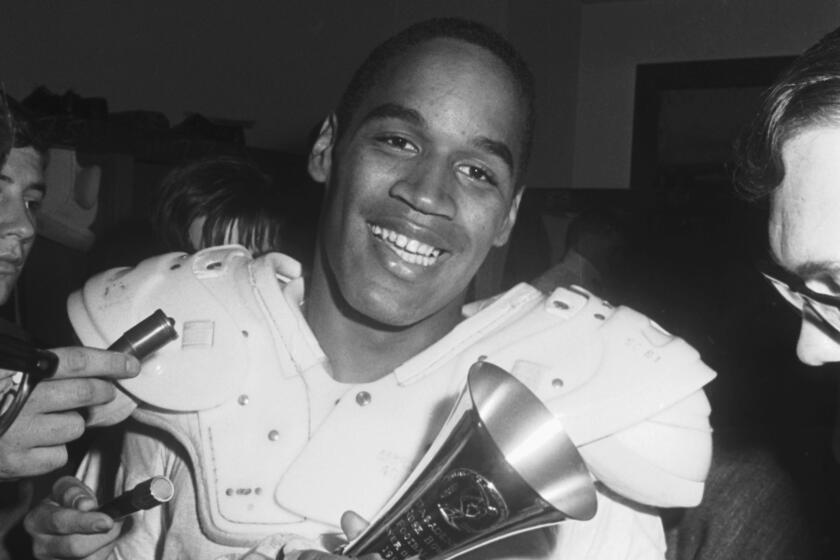 USC running back O.J. Simpson smiles as he holds the Player of the Game trophy following the 1967 Rose Bowl.