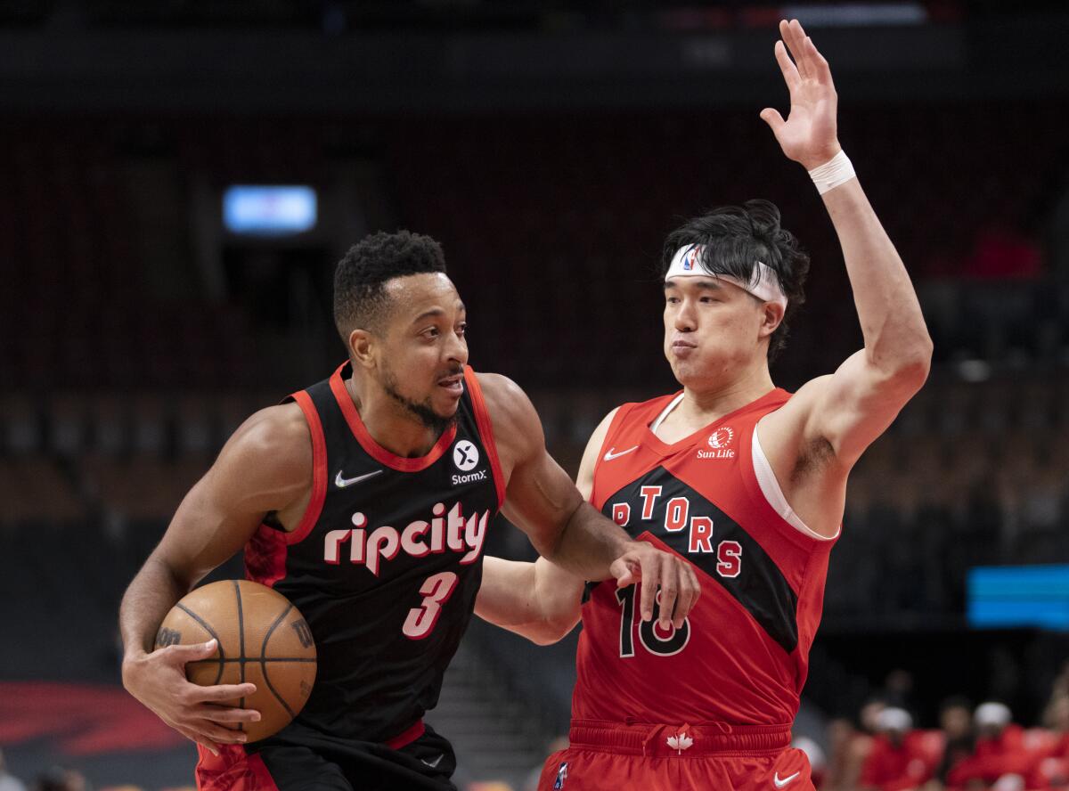 Portland Trail Blazers guard CJ McCollum (3) drives against Toronto Raptors forward Yuta Watanabe (18) during first-half NBA basketball game action in Toronto, Sunday Jan. 23, 2022. (Frank Gunn/The Canadian Press via AP)