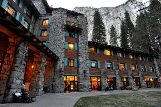 In this March 24, 2014 file photo, the historic Ahwahnee Hotel is lit up as dusk falls over Yosemite Valley, in Yosemite, Calif. The names of iconic hotels and other facilities in the world-famous Yosemite National Park will soon change in an ongoing battle over who owns the intellectual property, park officials said Thursday, Jan. 14, 2016. The famed Ahwahnee Hotel will become the Majestic Yosemite Hotel, and Curry Village will become Half Dome Village, said park spokesman Scott Gediman. (John Walker/Fresno Bee via AP)