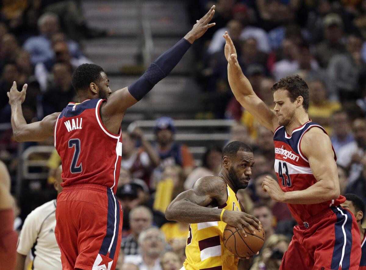 Wizards defenders John Wall (2) and Kris Humphries (43) try to trap Cavaliers forward LeBron James during the first half.