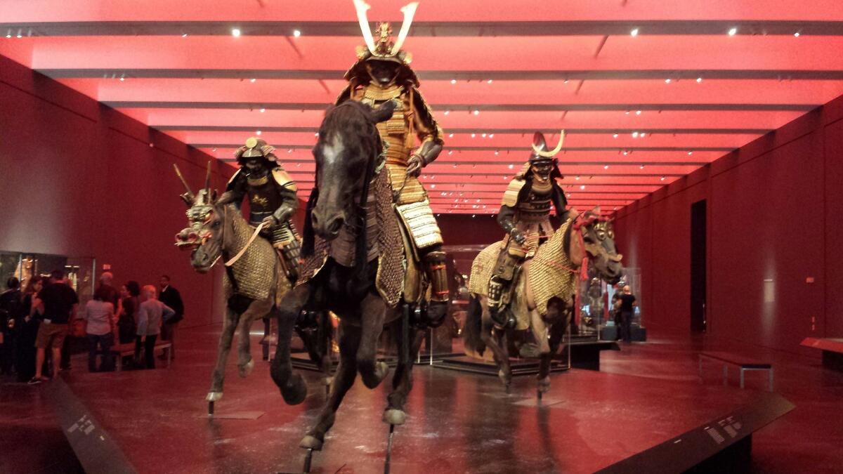 Warriors galloping on horseback are at the entry to the LACMA exhibition "Samurai."