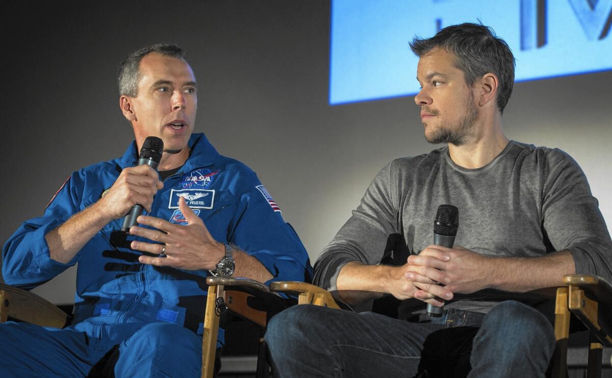 Astronaut Drew Feustel, left, speaks as actor Matt Damon listens during a question-and-answer session about NASA’s journey to Mars and the film "The Martian."