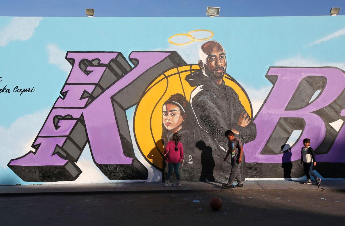 Children gather late last month in front of a newly painted mural honoring Kobe and Gianna Bryant on the side of El Toro Bravo market in Costa Mesa. Days earlier, the Bryants were killed along with seven other people in a helicopter crash in Calabasas.