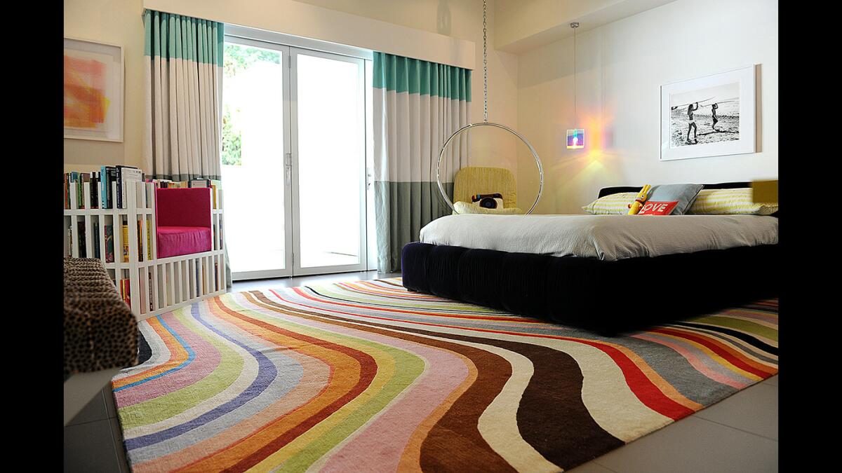 Laura Spira's bedroom includes a colorful Paul Smith carpet and a fun hanging bubble chair from Plush Pod.