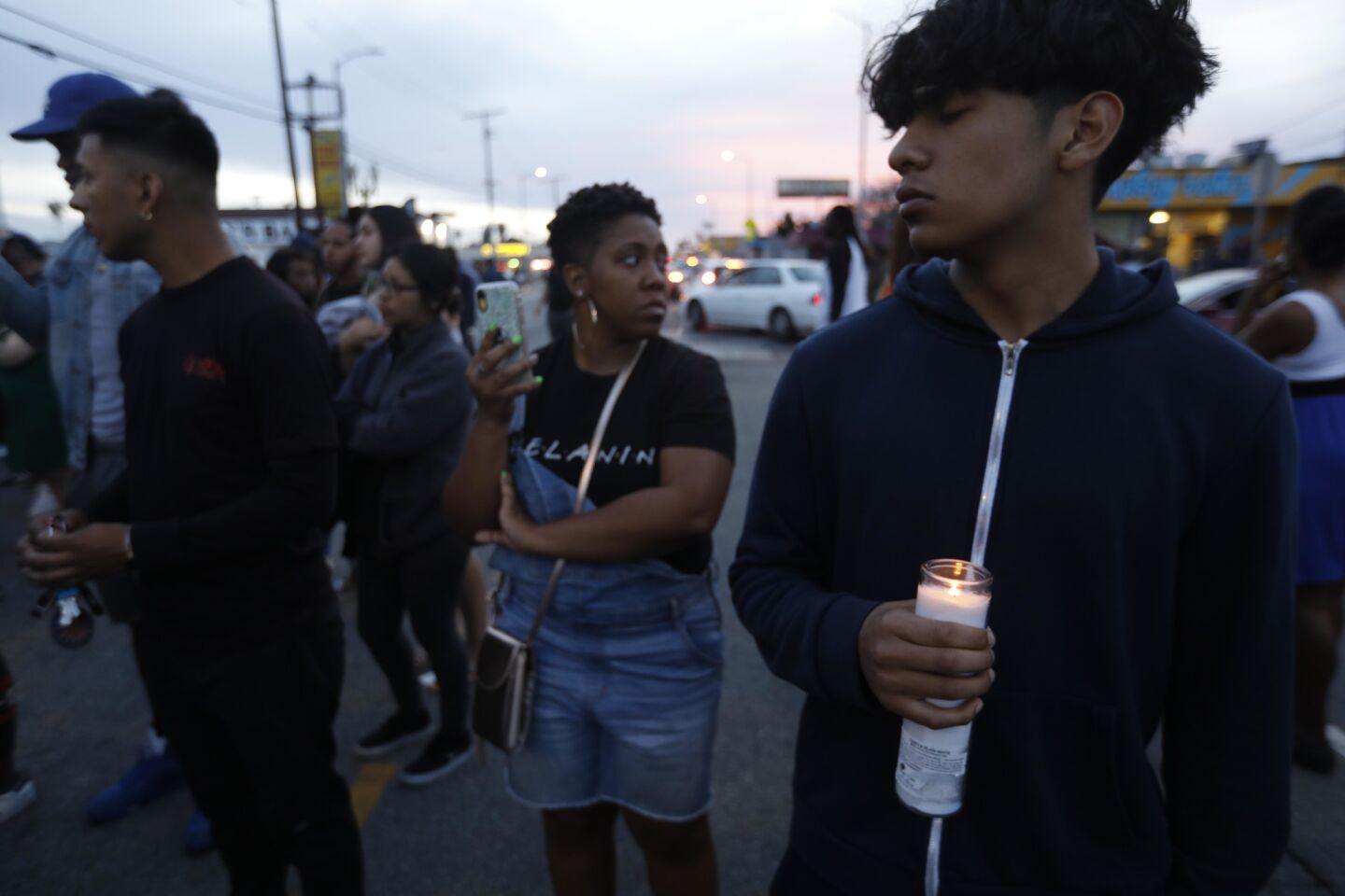 Hugo Rojas, 17, holds a candle in memory of rapper Nipsey Hussle, who was shot multiple times Sunday in South L.A.