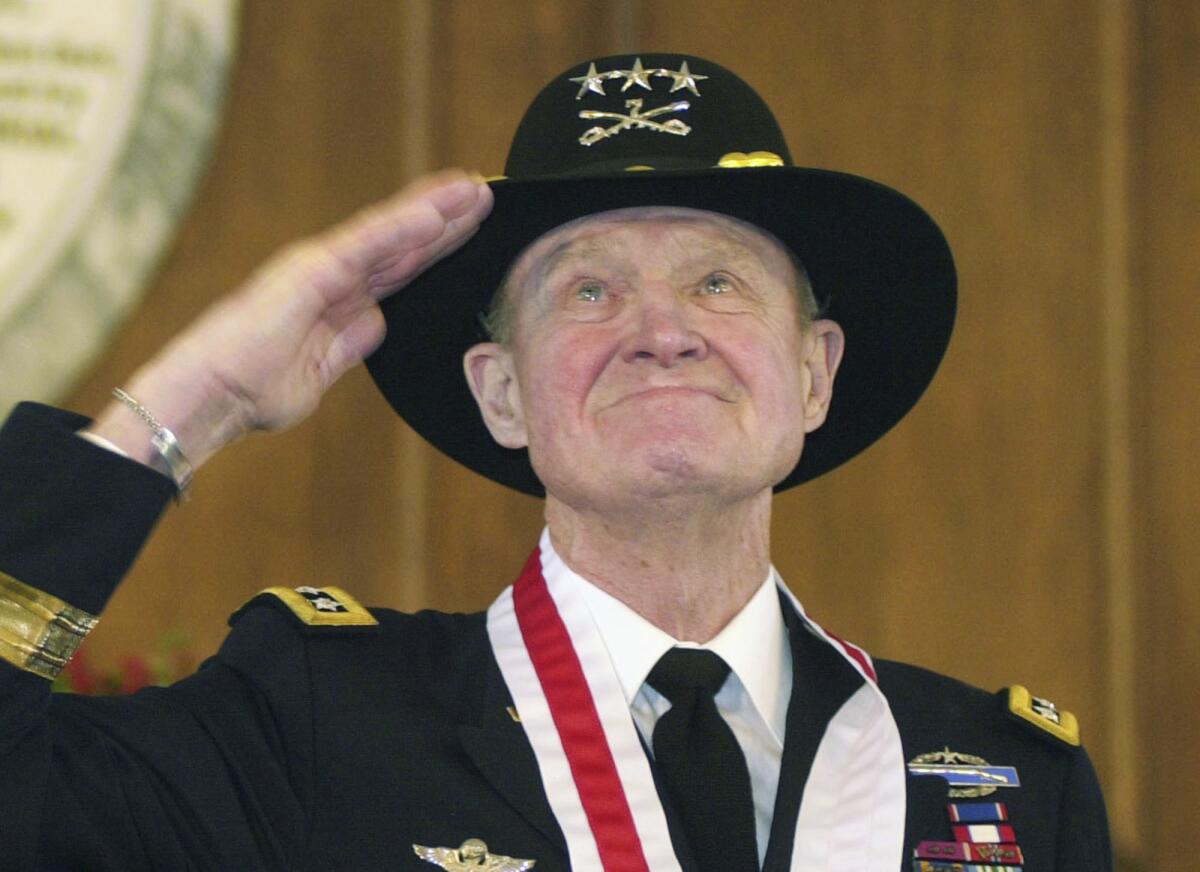 Retired Lt. Gen. Hal Moore salutes the crowd during a standing ovation at the state Capitol during the Spirit of Alabama Awards in Montgomery, Ala., in 2004.