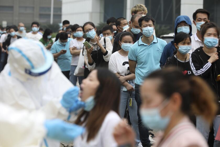 People line up for coronavirus testing at a large factory in Wuhan, China.