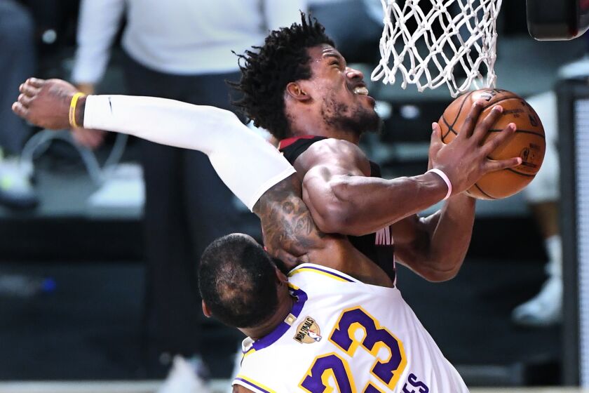 Lakers forward LeBron James fouls Miami forward Jimmy Butler.