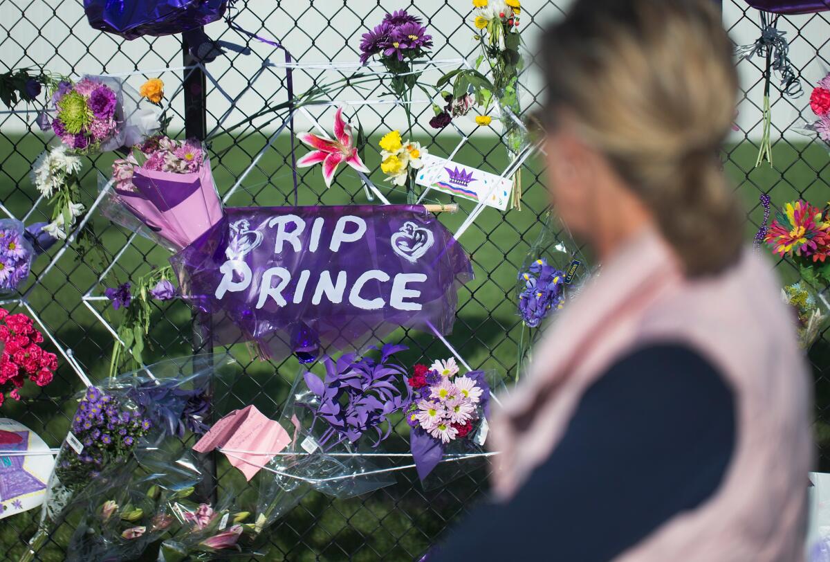 Music fans visit a memorial outside Paisley Park, Prince's home and studio in Chanhassen, Minn.